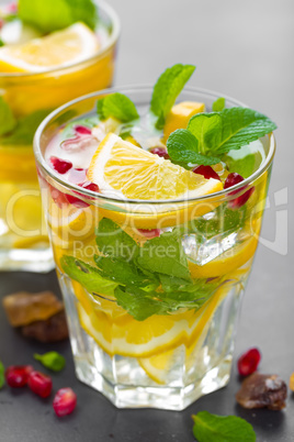 Lemon mojito cocktail with fresh mint and pomegranate, cold refreshing summer drink or beverage with ice