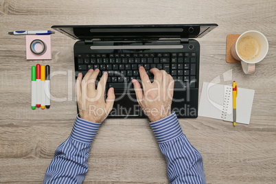 Male hand Working on laptop in his office while as he drinks coffee