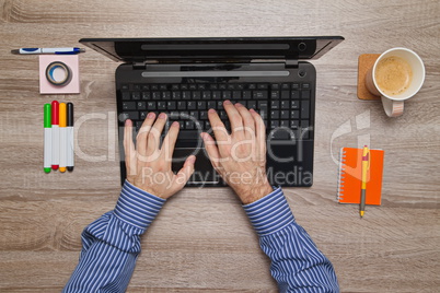 Male hand Working on laptop in his office while as he drinks coffee