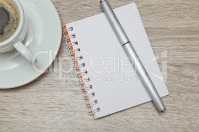 Office space with an empty note book at coffee time looking for inspirational ideas
