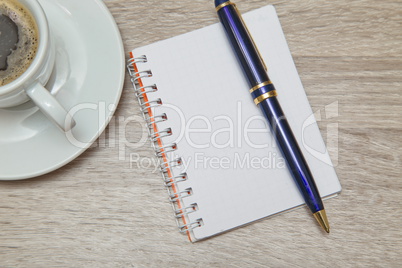 Office space with an empty note book at coffee time looking for inspirational ideas