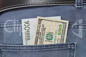 American dollar and Euros bills in jeans pocket background