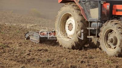 Tractor preparing land for sowing close shot