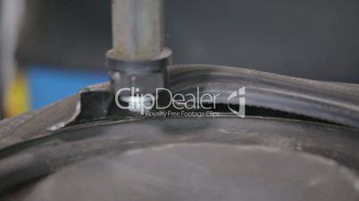 Man put on tire on car wheel by special tool, closeup view