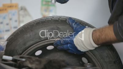 Mechanic precision spin balance and installs a new tire on a car wheel rim