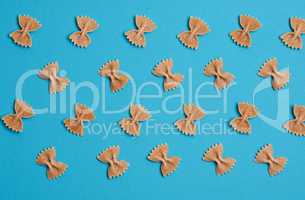 Organic whole grain farfalle on blue