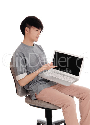 Asian teenager pointing at his laptop.