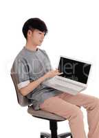 Asian teenager pointing at his laptop.