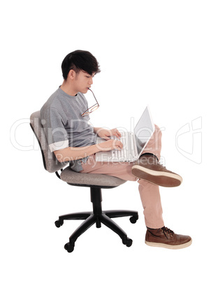 Korean man typing at his laptop.