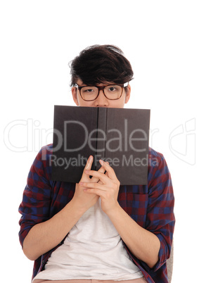 Asian man holding book for face.