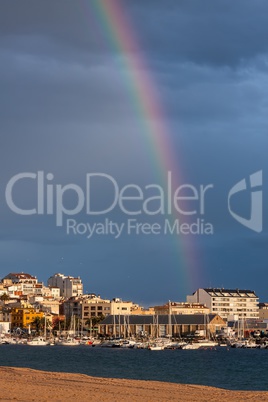 Beautiful rainbow over small town (Palamos)  in Spain