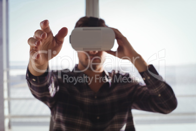 Businessman gesturing while using virtual reality headset in office