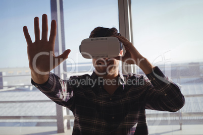 Businessman experiencing virtual reality in creative office