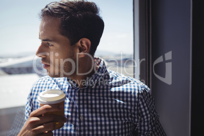 Close up of thoughtful businessman holding coffee cup in office