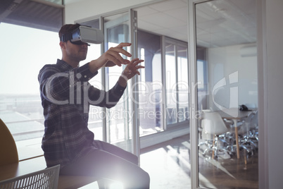 Businessman gesturing while experiencing virtual reality in office