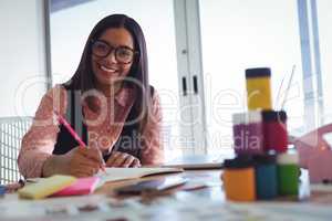 Portrait of smiling young businesswoman working at office