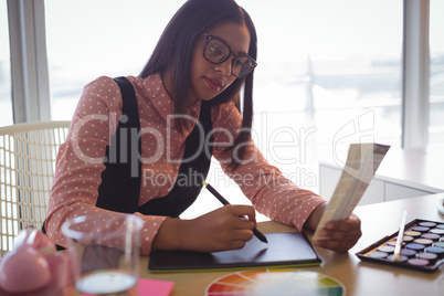 Focused businesswoman working on digitizer at office