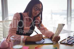 Focused businesswoman working on digitizer at office