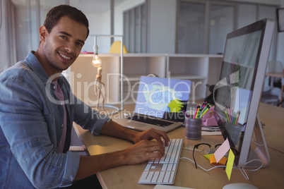 Portrait of smiling businessman working on at office