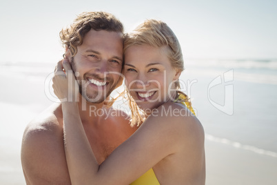 Portrait of smiling couple embracing at beach