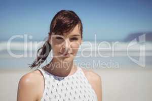 Portrait of young woman standing at beach