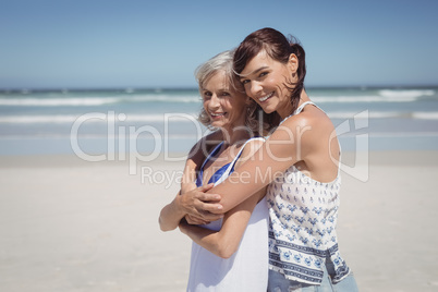Portrait of happy woman embracing her mother at beach