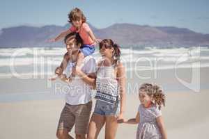 Happy family walking at beach