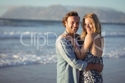 Portrait of smiling couple hugging at beach
