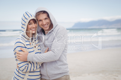 Portrait of smiling couple wearing hooded sweater during winter