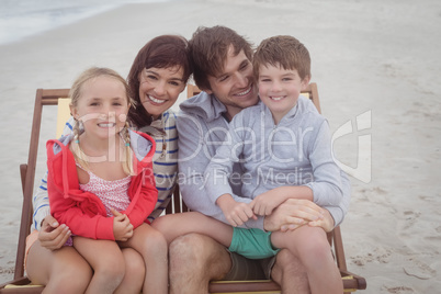 Happy family resting on lounge chairs