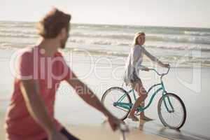 Couple riding bicycle at beach