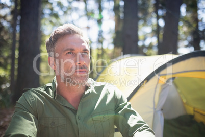 Thoughtful mature man on sunny day in forest