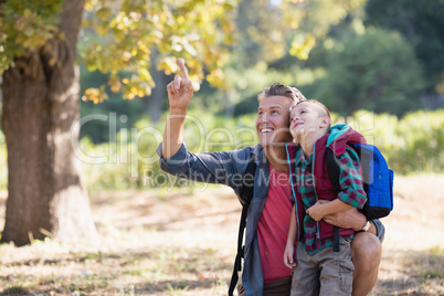 Father pointing to boy in forest