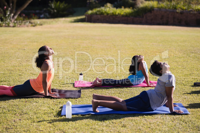 Instructor practicing stretching with children on mat