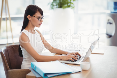 Attentive executive using laptop at desk