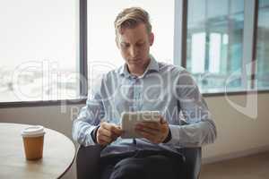 Attentive executive using digital tablet at table