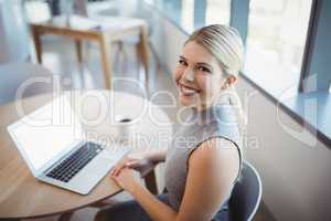 Portrait of female executive using laptop at her desk