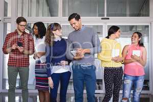 Business people with tablet computers standing in corridor