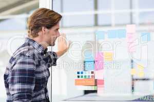 Businessman looking at plan on wall
