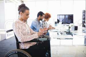 Businesswoman using digital tablet while sitting on wheelchair