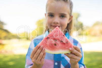 Girl holding watermelon slice in the park