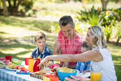 Happy family having meal in park