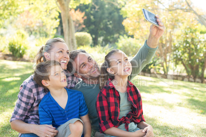 Happy family taking a selfie in the park