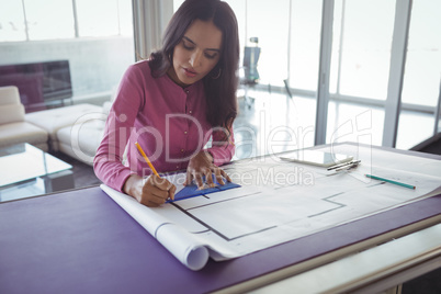 Female interior making diagrams on paper in office