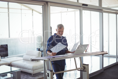 Interior designer analyzing diagrams on papers in office