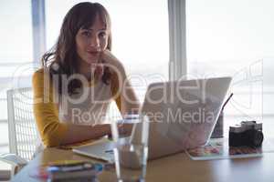 Portrait of young businesswoman sitting at office desk