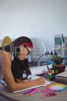 Businesswoman working on desk at creative office