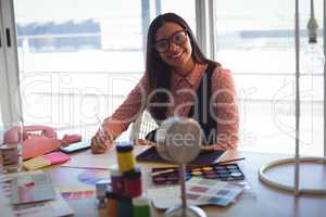 Portrait of businesswoman writing on paper at office