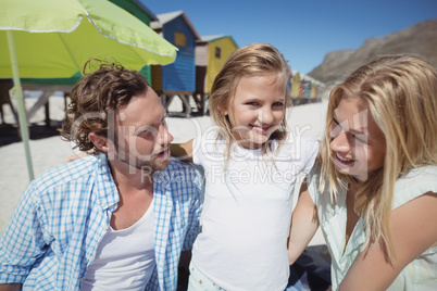 Smiling girl with parents at beach