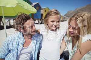 Smiling girl with parents at beach